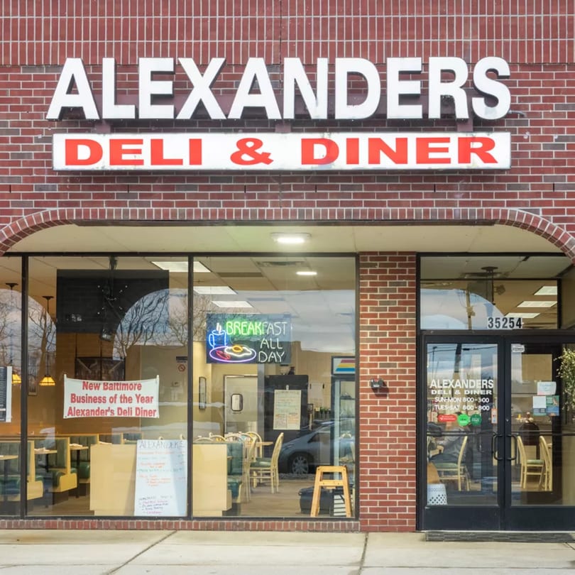 Exterior of Alexander's Deli Diner, a brick building with large windows and a prominent sign.